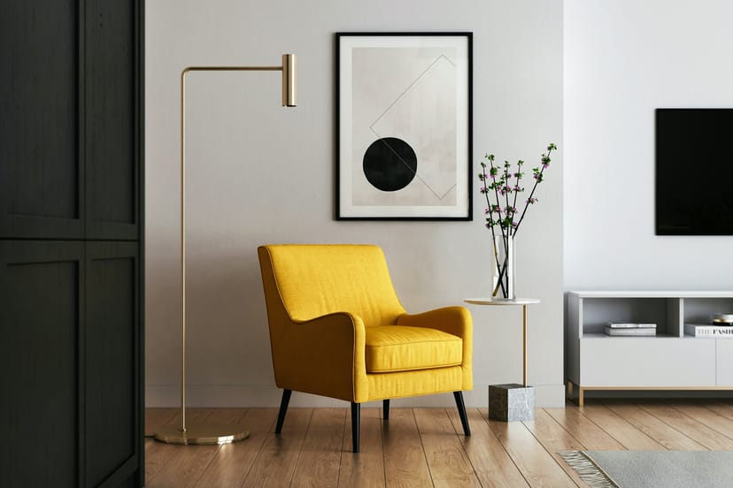 Fauteuil jaune moutarde et lampadaire doré dans un salon blanc