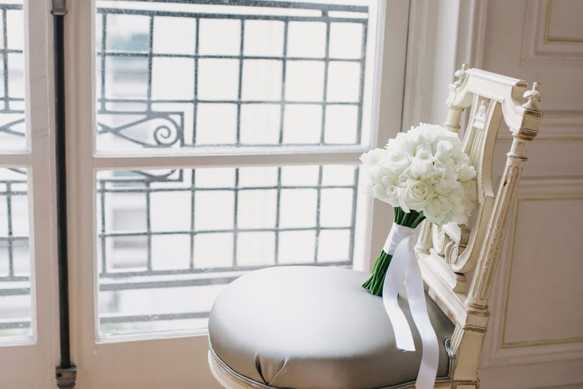 Chaise blanche et bouquet devant une fenêtre à petits carreaux