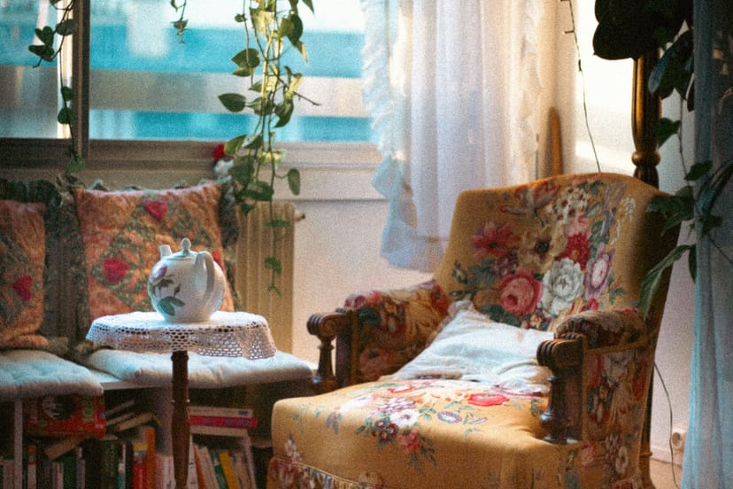 Coin salon aux fauteuils fleuris devant une fenêtre